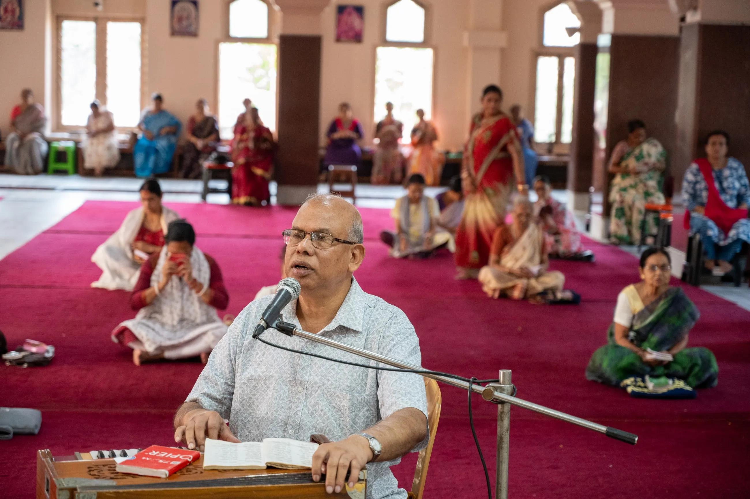 A devotee leading bhajan at the harmonium