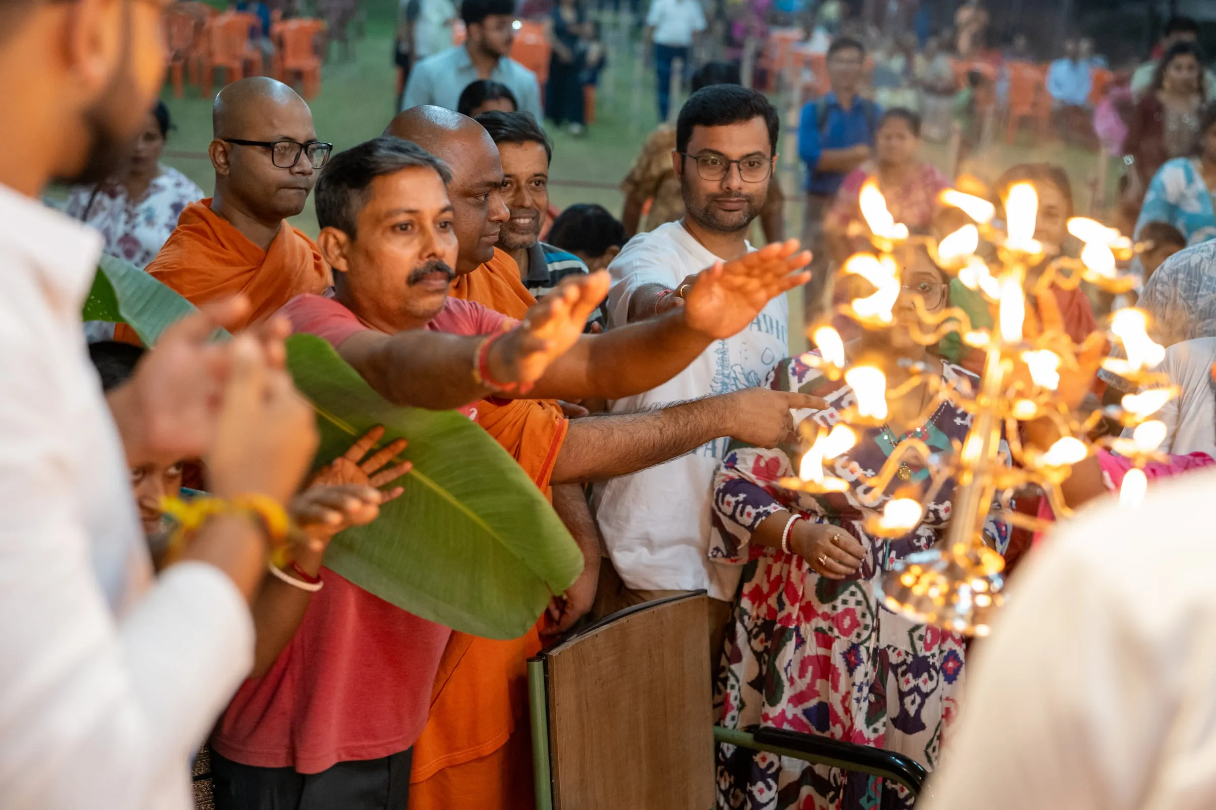 Devotees taking the arati flame at Durga Puja