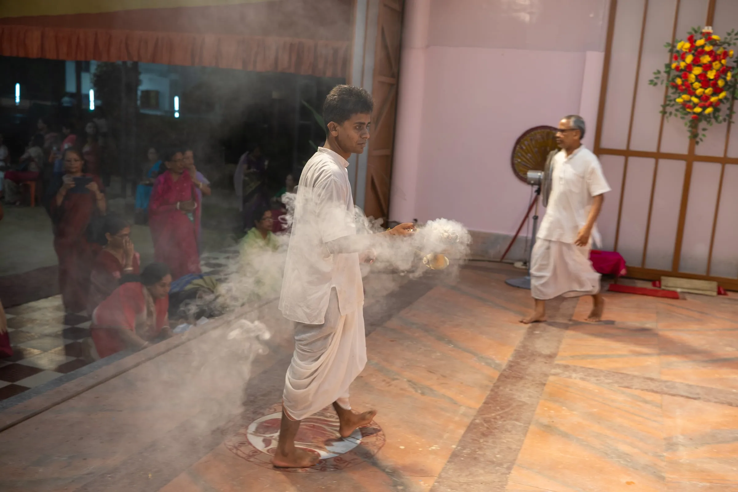 Dhunuchi smoke carried through the mandap