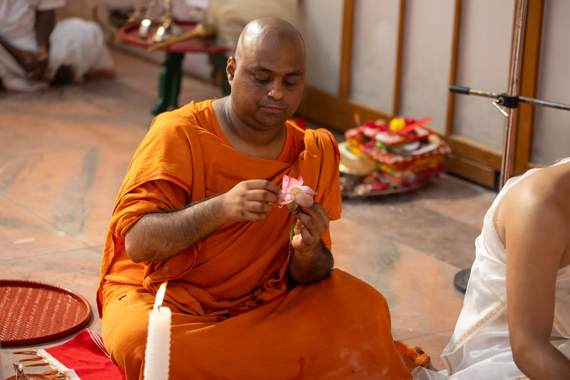 A monk holding a lotus during the puja