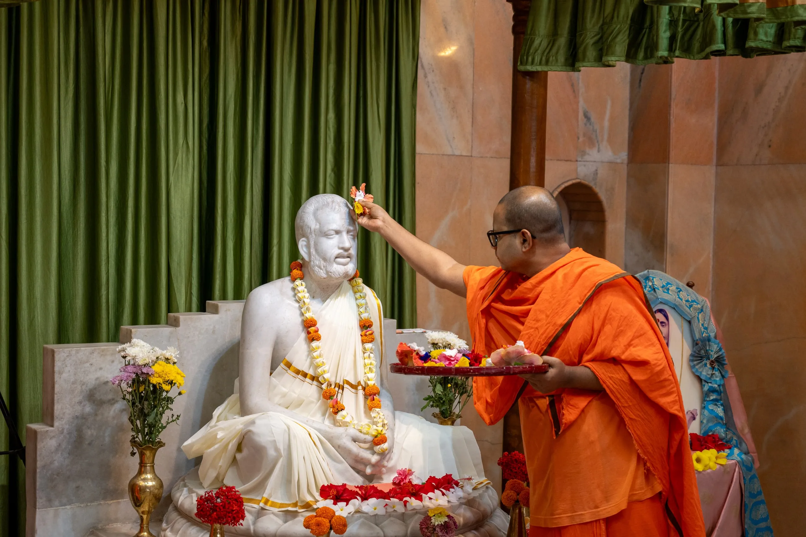 A monk offering a flower at the image of Sri Ramakrishna