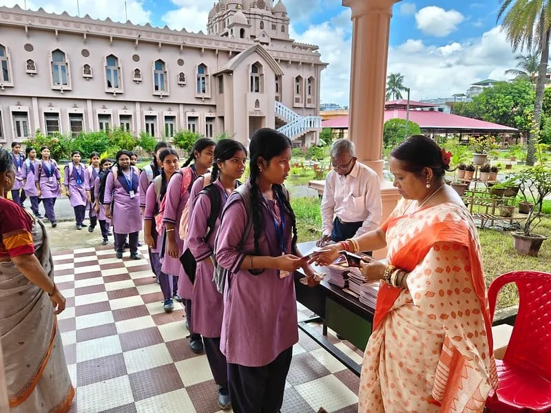 Books being handed to visiting students outside the temple